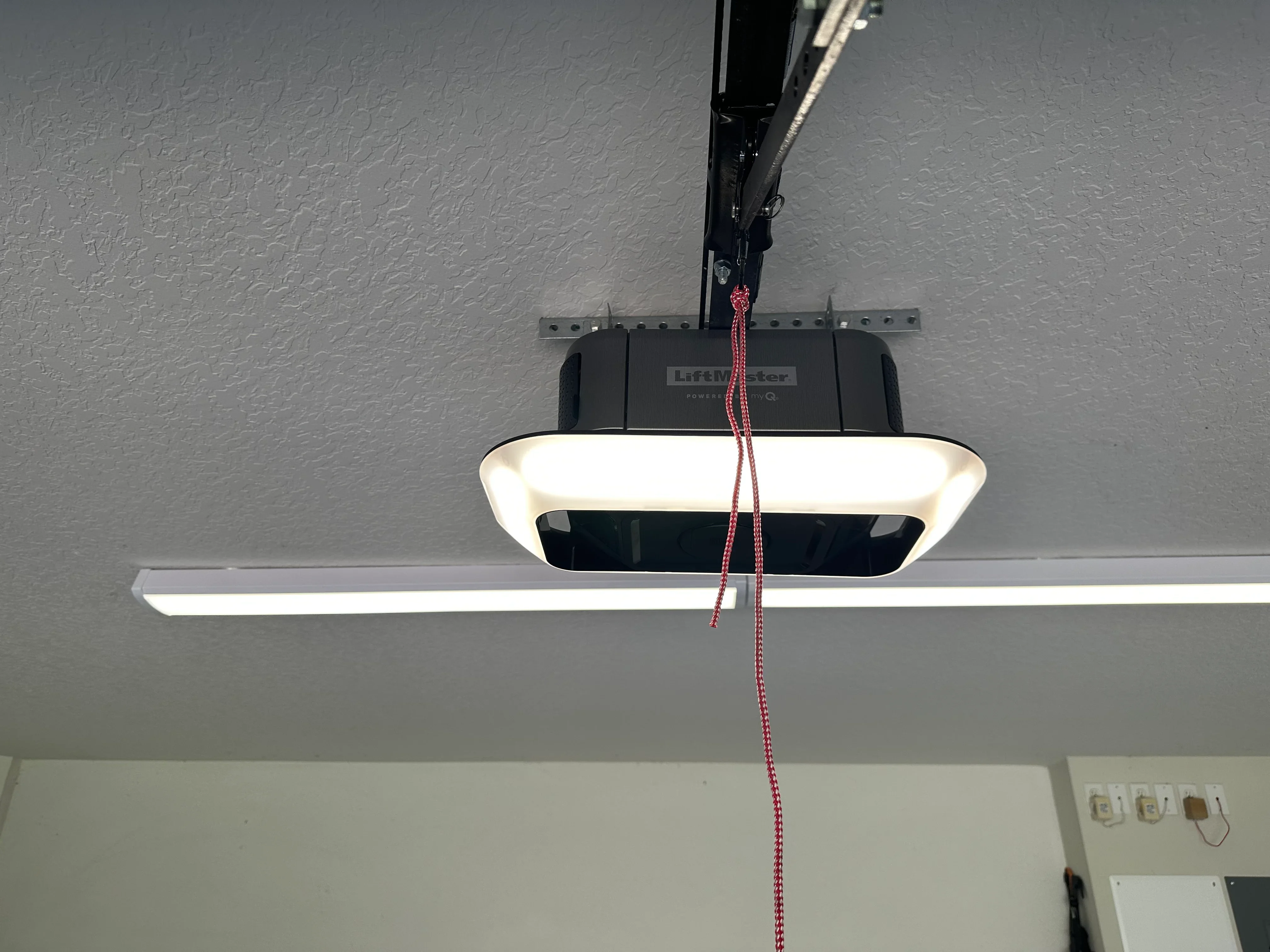 Technician performing garage door maintenance inspection on residential door