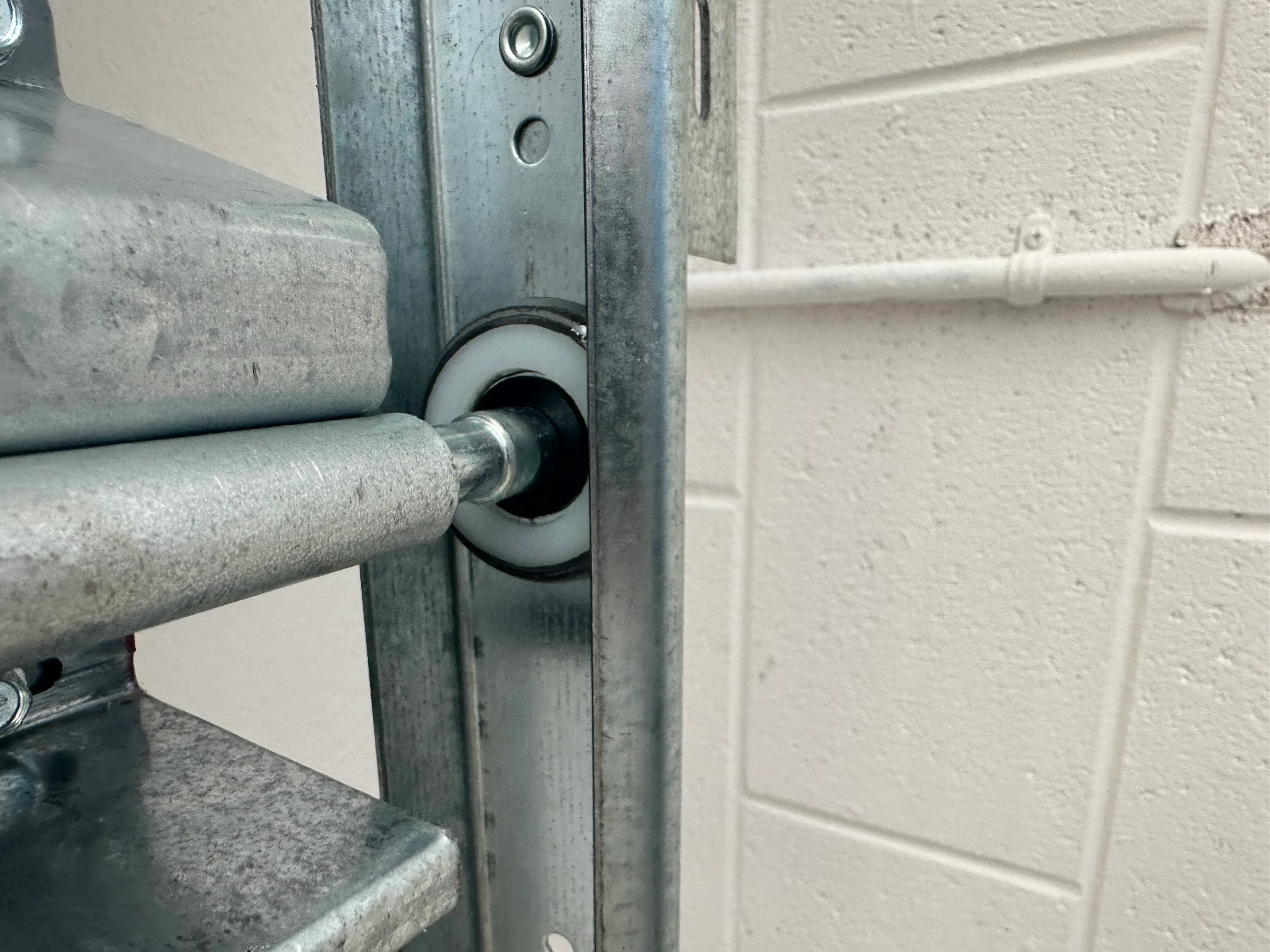 Garage door roller and track assembly inspection showing metal hardware and alignment